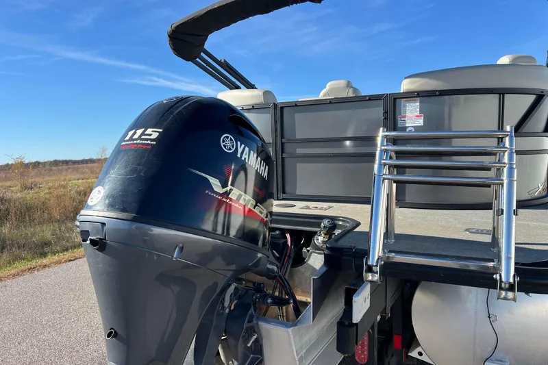 Slide: The Image of 2022 Sylvan Mirage X1 Tritoon with Yamaha 115 engine and ladder, parked outdoors. - 8