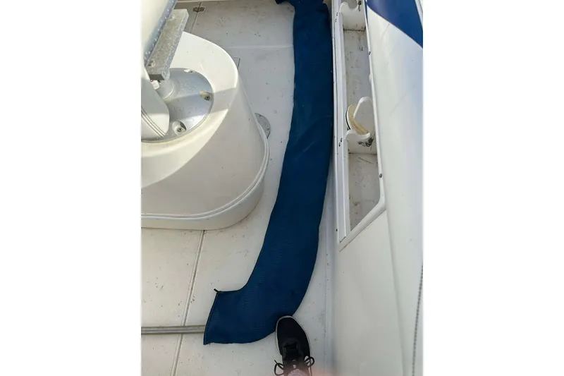 Slide: The Image of 1995 Wellcraft 302 Scarab Sport deck with blue cover and foot visible. - 16