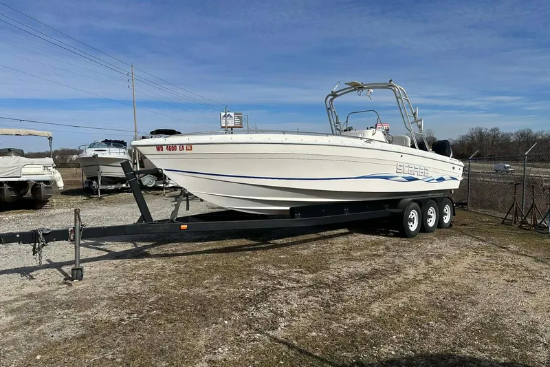 Slide: The Image of 1995 Wellcraft 302 Scarab Sport boat on trailer, parked outdoors under clear sky. - 23