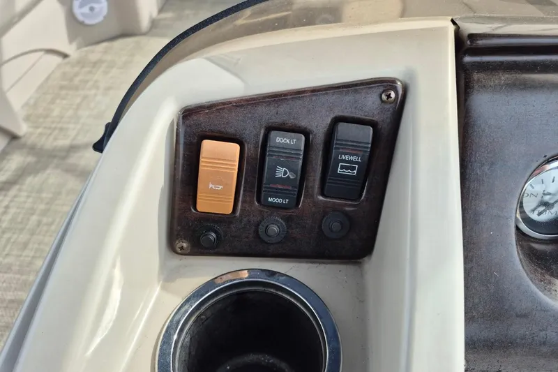 Slide: The Image of Control panel of a 2015 Bennington 24SSRX boat with switches and cup holder. - 15