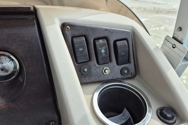 Slide: The Image of Control panel of a 2015 Bennington 24SSRX boat with switches and a cup holder. - 17
