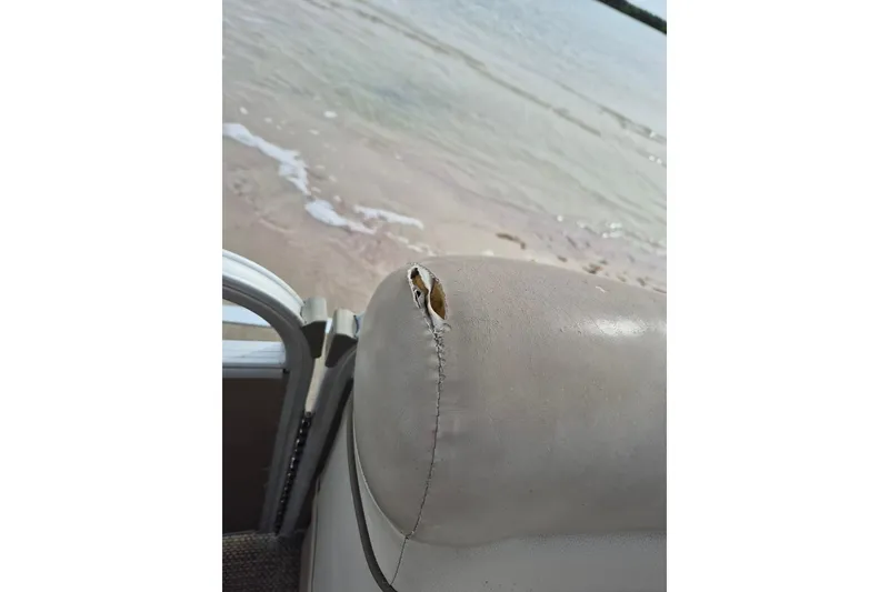 Slide: The Image of Torn seat on 2015 Bennington 24SSRX boat by the water. - 20