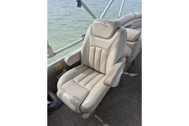 Slide: The Image of Luxury seating on a 2015 Bennington 24SSRX pontoon boat, overlooking calm waters. - 21