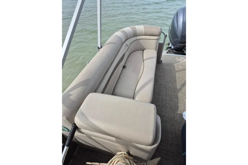 Slide: The Image of 2015 Bennington 24SSRX boat interior with beige seating and water view. - 22