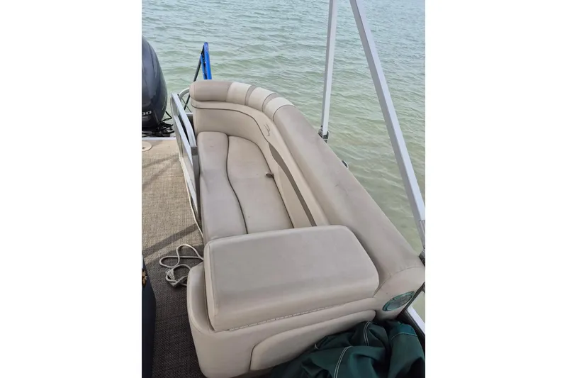 Slide: The Image of 2015 Bennington 24SSRX pontoon boat with beige seating, on calm water. - 23