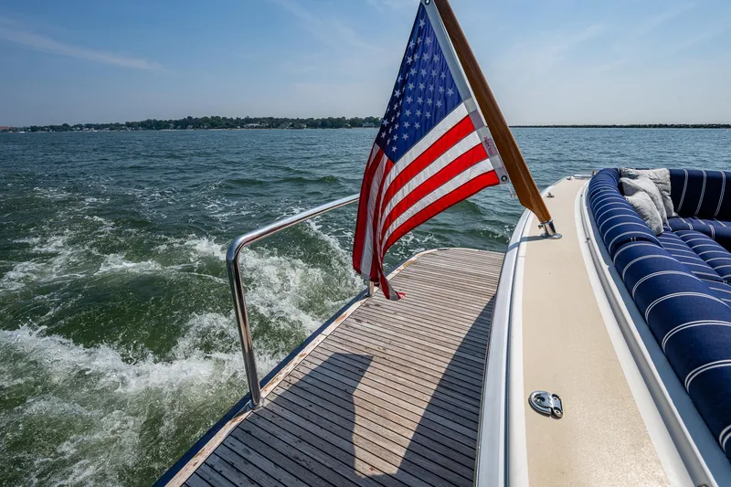 Slide: The Image of Grand Banks 44 Eastbay SX 2017 yacht with American flag on deck, cruising on open water. - 9