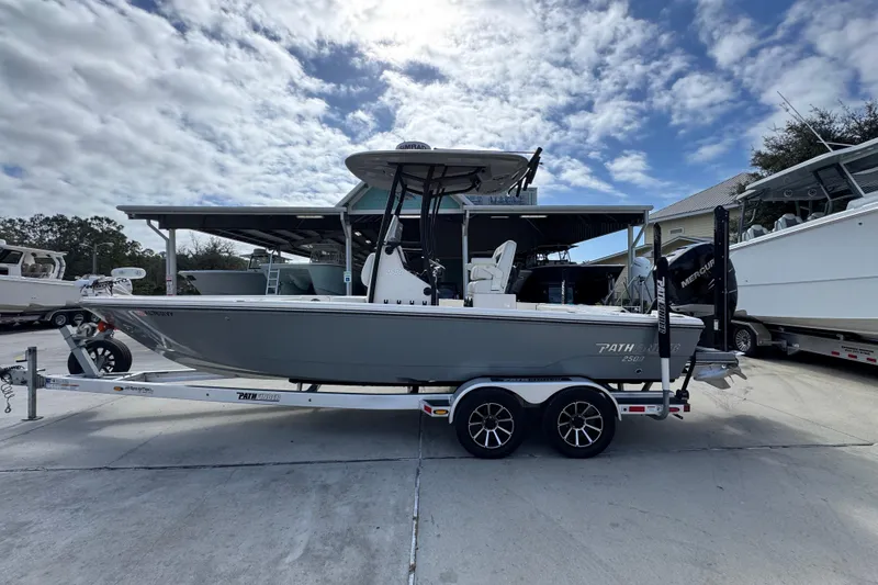The Image of 2023 Pathfinder 2500 Hybrid boat on trailer under cloudy sky. - 1