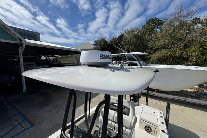 Slide: The Image of 2023 Pathfinder 2500 Hybrid boat with radar, parked outdoors under a blue sky. - 23