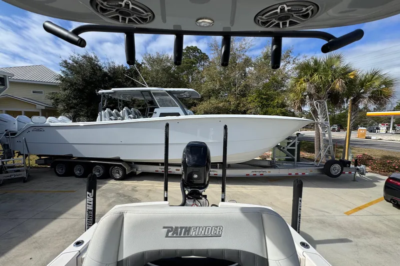 Slide: The Image of 2023 Pathfinder 2500 Hybrid boat on trailer, parked outdoors with palm trees. - 29
