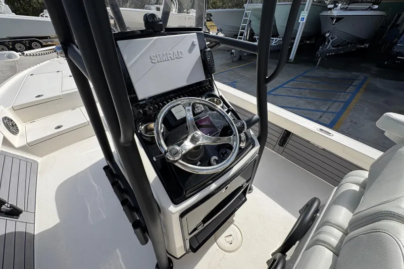 Slide: The Image of 2023 Pathfinder 2500 Hybrid boat console with steering wheel and Simrad display. - 30