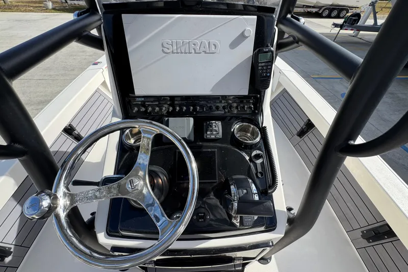 Slide: The Image of 2023 Pathfinder 2500 Hybrid boat console with steering wheel and Simrad display. - 31