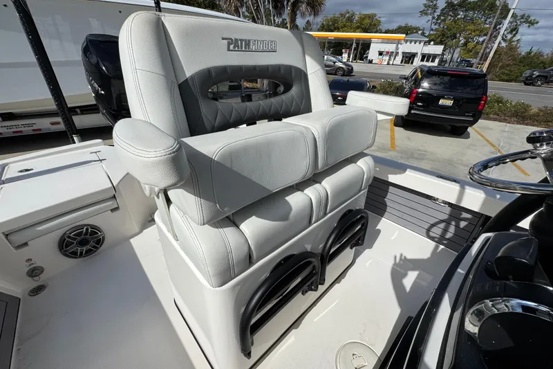 Slide: The Image of 2023 Pathfinder 2500 Hybrid boat seat with armrests, parked near a gas station. - 34