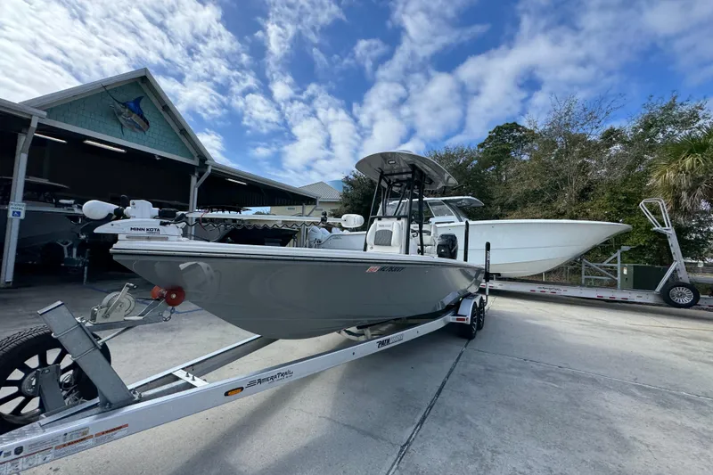 Slide: The Image of 2023 Pathfinder 2500 Hybrid boat on trailer, parked outdoors under a partly cloudy sky. - 4