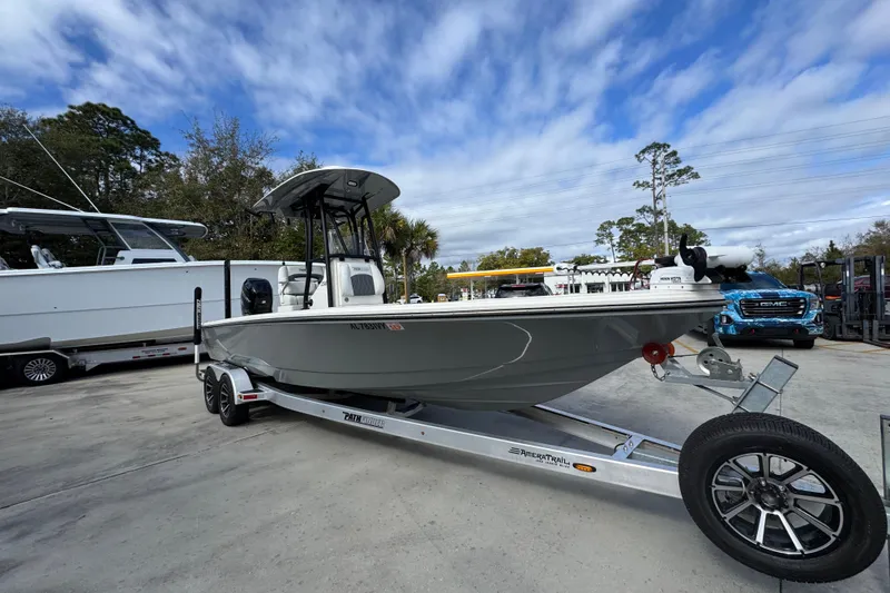 Slide: The Image of 2023 Pathfinder 2500 Hybrid boat on trailer, parked outdoors under a cloudy sky. - 7