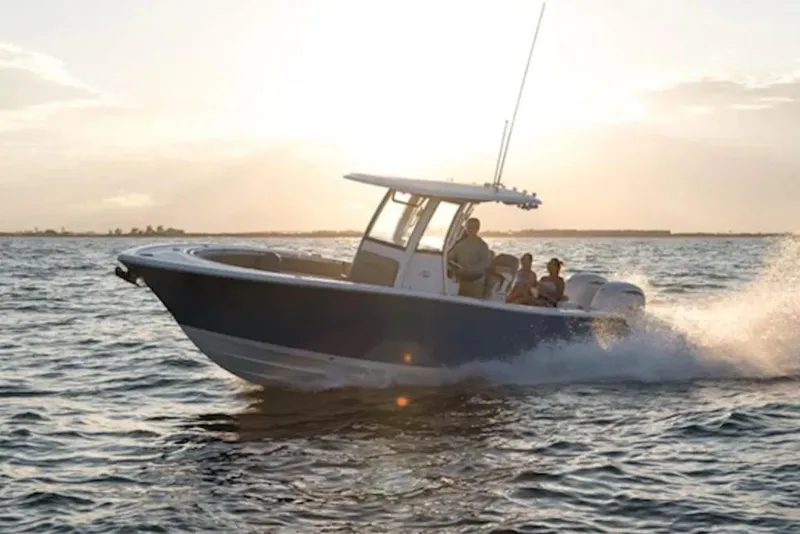 The Image of 2026 Sportsman Open 252 Center Console boat cruising on the water at sunset. - 1