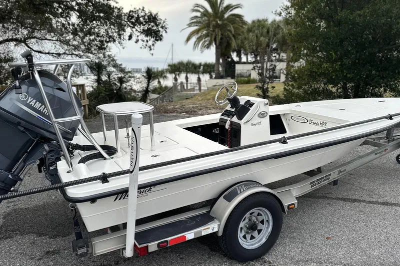 Slide: The Image of 2014 Maverick 17 HPX-V boat on trailer with Yamaha outboard motor, parked near waterfront. - 2