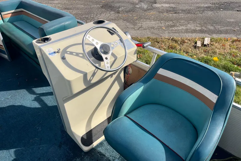 Slide: The Image of 1989 Harris FloteBote 240 Classic pontoon boat interior with steering wheel and blue seating. - 4