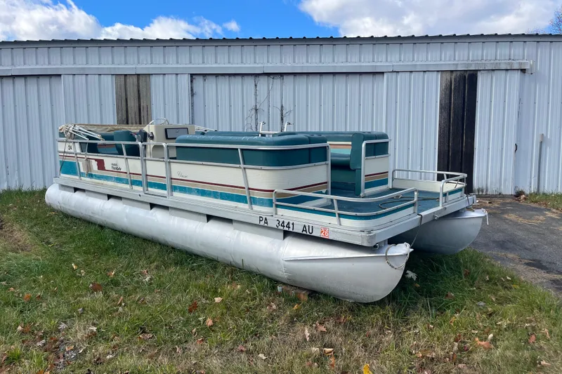 Slide: The Image of 1989 Harris FloteBote 240 Classic pontoon boat near a metal building. - 7