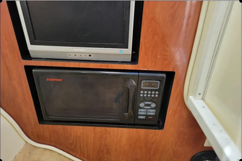 Slide: The Image of Built-in Sharp TV and Tappan microwave in 2004 Monterey 298SS Super Sport boat interior. - 27
