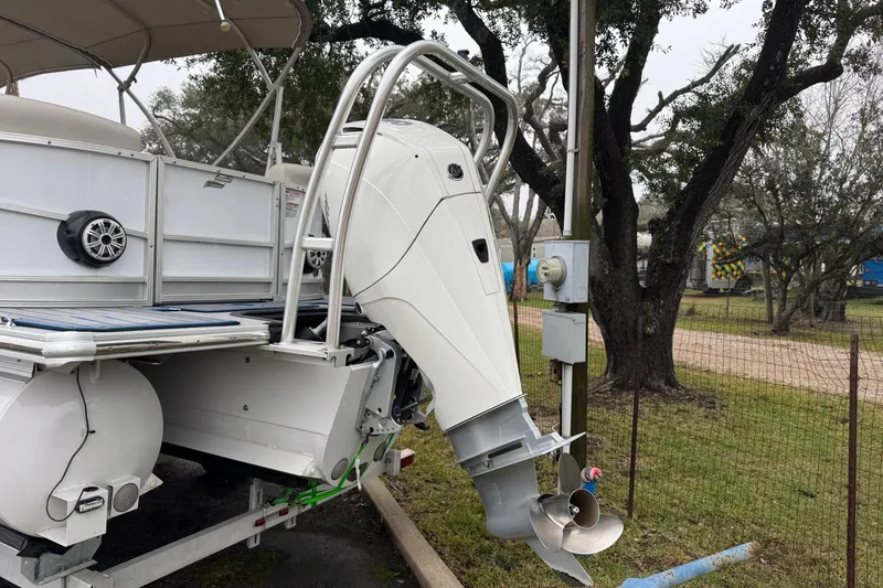 Slide: The Image of 2004 Monterey 298SS Super Sport boat with outboard motor, parked outdoors near trees. - 3