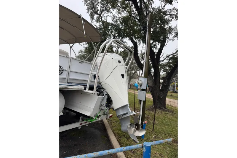 Slide: The Image of 2004 Monterey 298SS Super Sport boat with outboard motor, parked near trees. - 4