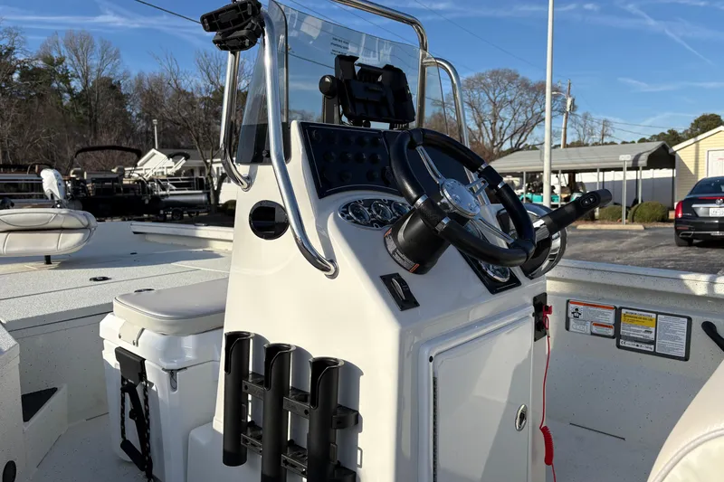 Slide: The Image of 2026 Ranger RB200 boat console with steering wheel and rod holders, parked outdoors. - 7
