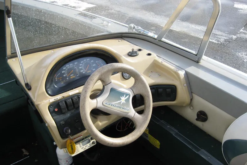 Slide: The Image of Dashboard of a 1999 Starcraft Pro-Elite 2000 boat with steering wheel and gauges. - 14