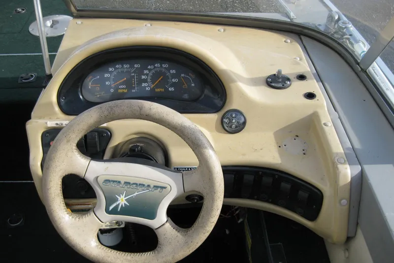 Slide: The Image of Dashboard of a 1999 Starcraft Pro-Elite 2000 boat with steering wheel and gauges. - 15