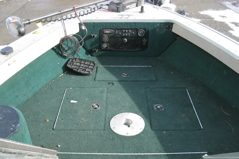 Slide: The Image of Interior of a 1999 Starcraft Pro-Elite 2000 boat with green carpet and control panel. - 16