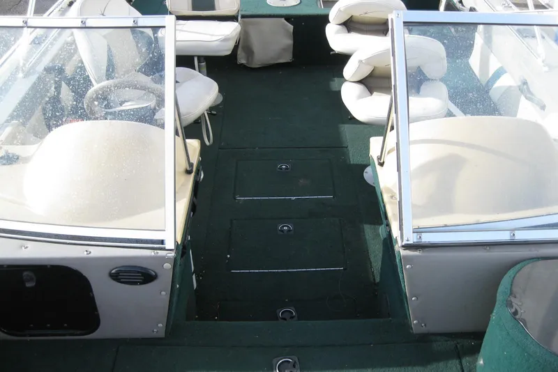 Slide: The Image of 1999 Starcraft Pro-Elite 2000 boat interior with green carpet and white seating. - 21