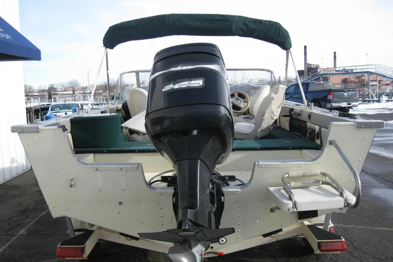 Slide: The Image of 1999 Starcraft Pro-Elite 2000 boat with outboard motor, docked at marina. - 6