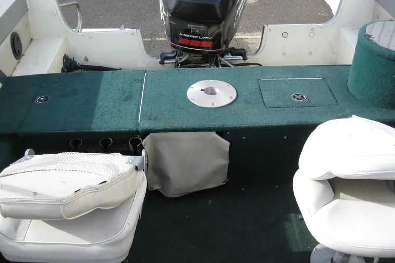 Slide: The Image of Interior of a 1999 Starcraft Pro-Elite 2000 boat with seating and motor. - 8
