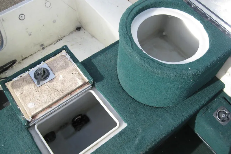 Slide: The Image of 1999 Starcraft Pro-Elite 2000 boat interior with green carpet and storage compartments. - 9