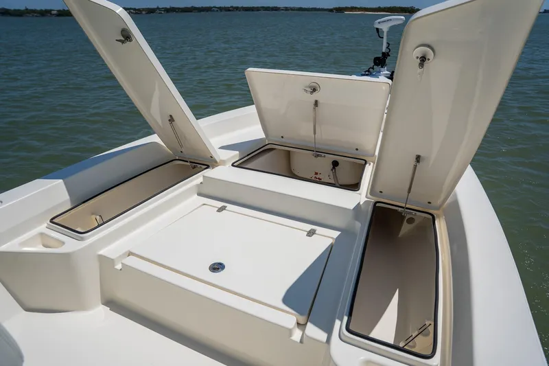 Slide: The Image of 2018 Pathfinder 2400 TRS boat with open storage compartments on calm water. - 23