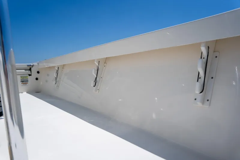 Slide: The Image of 2018 Pathfinder 2400 TRS boat interior detail with rod holders under clear blue sky. - 41