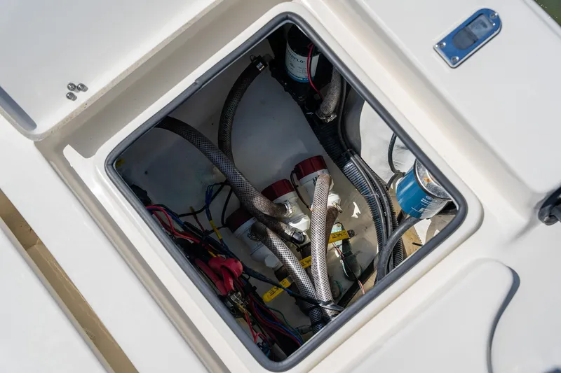 Slide: The Image of 2018 Pathfinder 2400 TRS boat compartment with wiring and hoses visible. - 50