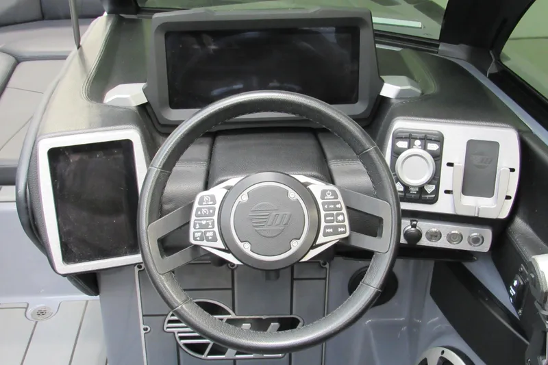 Slide: The Image of 2021 Malibu Wakesetter 24 MXZ dashboard with steering wheel and control panels. - 10