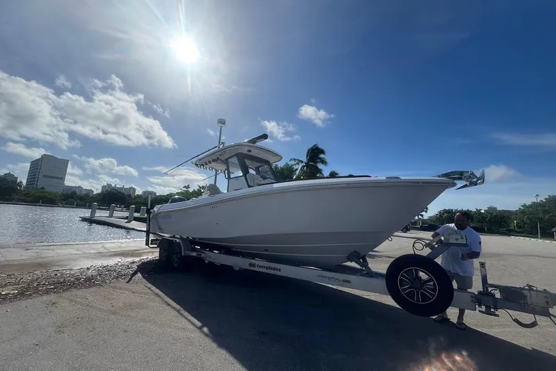The Image of 2021 Everglades 295 Center Console boat on trailer under sunny sky. - 0