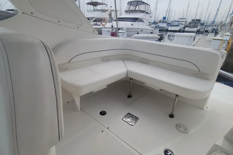 Slide: The Image of 2011 Bayliner 315 Cruiser interior with white seating, docked at marina. - 11