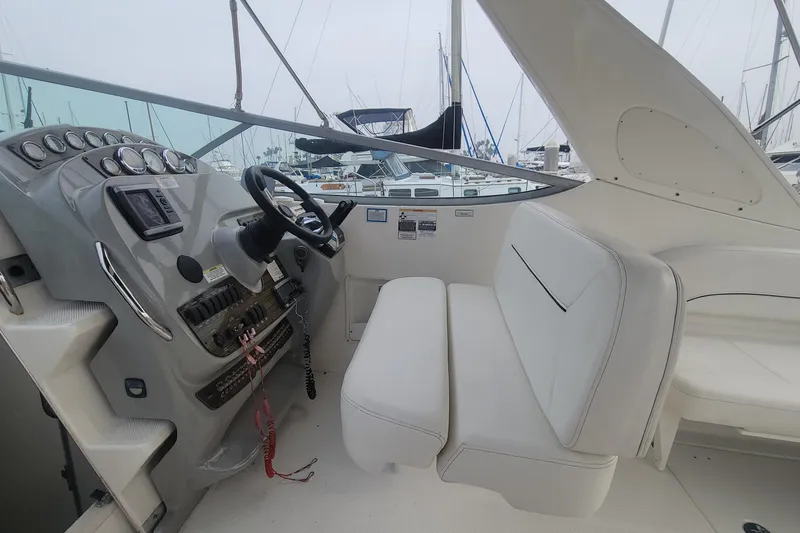 Slide: The Image of 2011 Bayliner 315 Cruiser helm with steering wheel and control panel, docked at marina. - 12