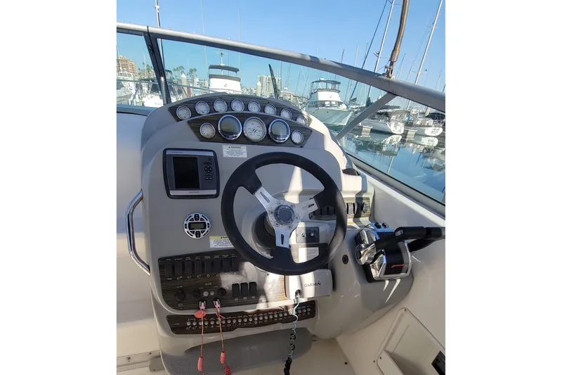 Slide: The Image of 2011 Bayliner 315 Cruiser helm with steering wheel and control panel, docked at marina. - 14