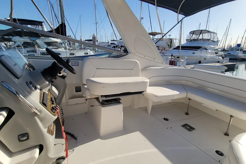 Slide: The Image of 2011 Bayliner 315 Cruiser interior with helm, seating, and marina view. - 17