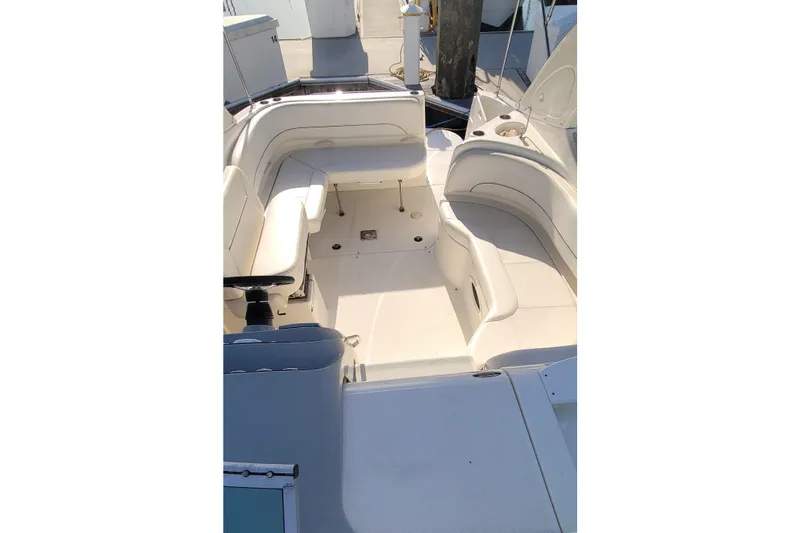 Slide: The Image of 2011 Bayliner 315 Cruiser interior with white seating and helm, docked at marina. - 22