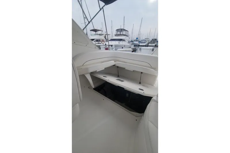 Slide: The Image of 2011 Bayliner 315 Cruiser interior with open storage compartment, docked at marina. - 23