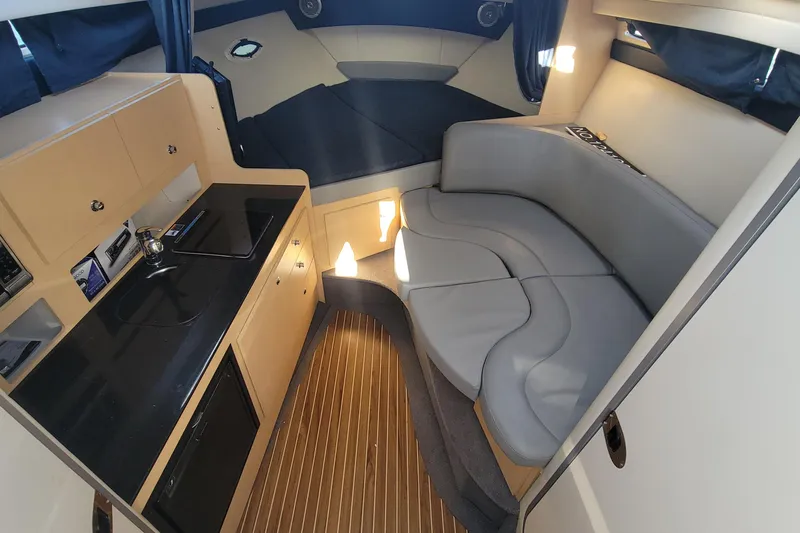 Slide: The Image of 2011 Bayliner 315 Cruiser interior with kitchenette, seating, and wood flooring. - 29
