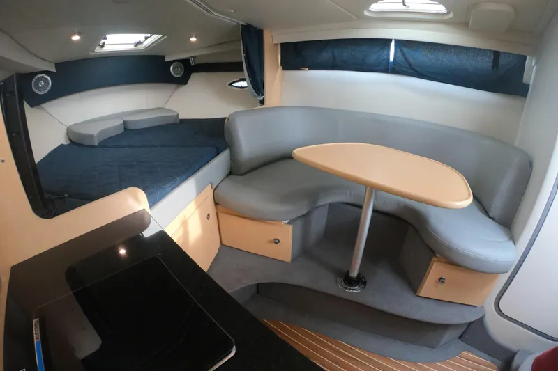 Slide: The Image of 2011 Bayliner 315 Cruiser interior with seating, table, and bed. - 33