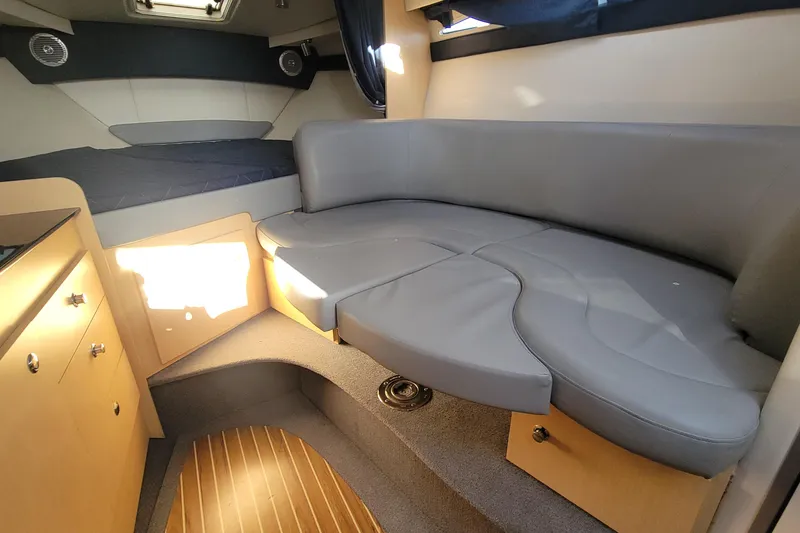 Slide: The Image of 2011 Bayliner 315 Cruiser interior with gray seating and wood accents. - 35