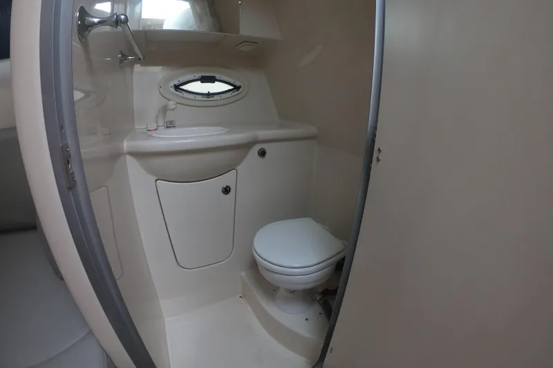 Slide: The Image of 2011 Bayliner 315 Cruiser bathroom with sink, toilet, and porthole window. - 36