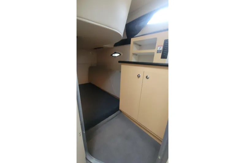Slide: The Image of 2011 Bayliner 315 Cruiser interior cabin with storage cabinets and carpeted flooring. - 37