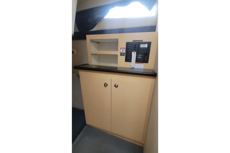 Slide: The Image of 2011 Bayliner 315 Cruiser interior cabinet with control panel and shelving. - 39
